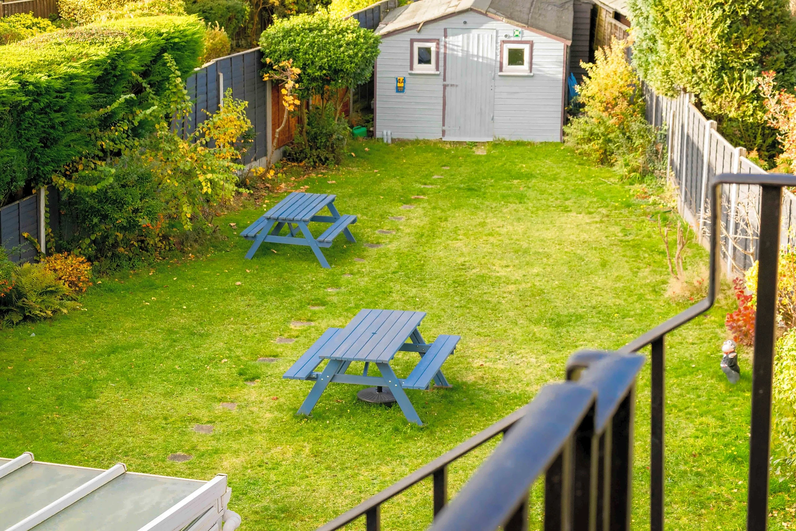 The hotel's lawned garden with blue picnic benches