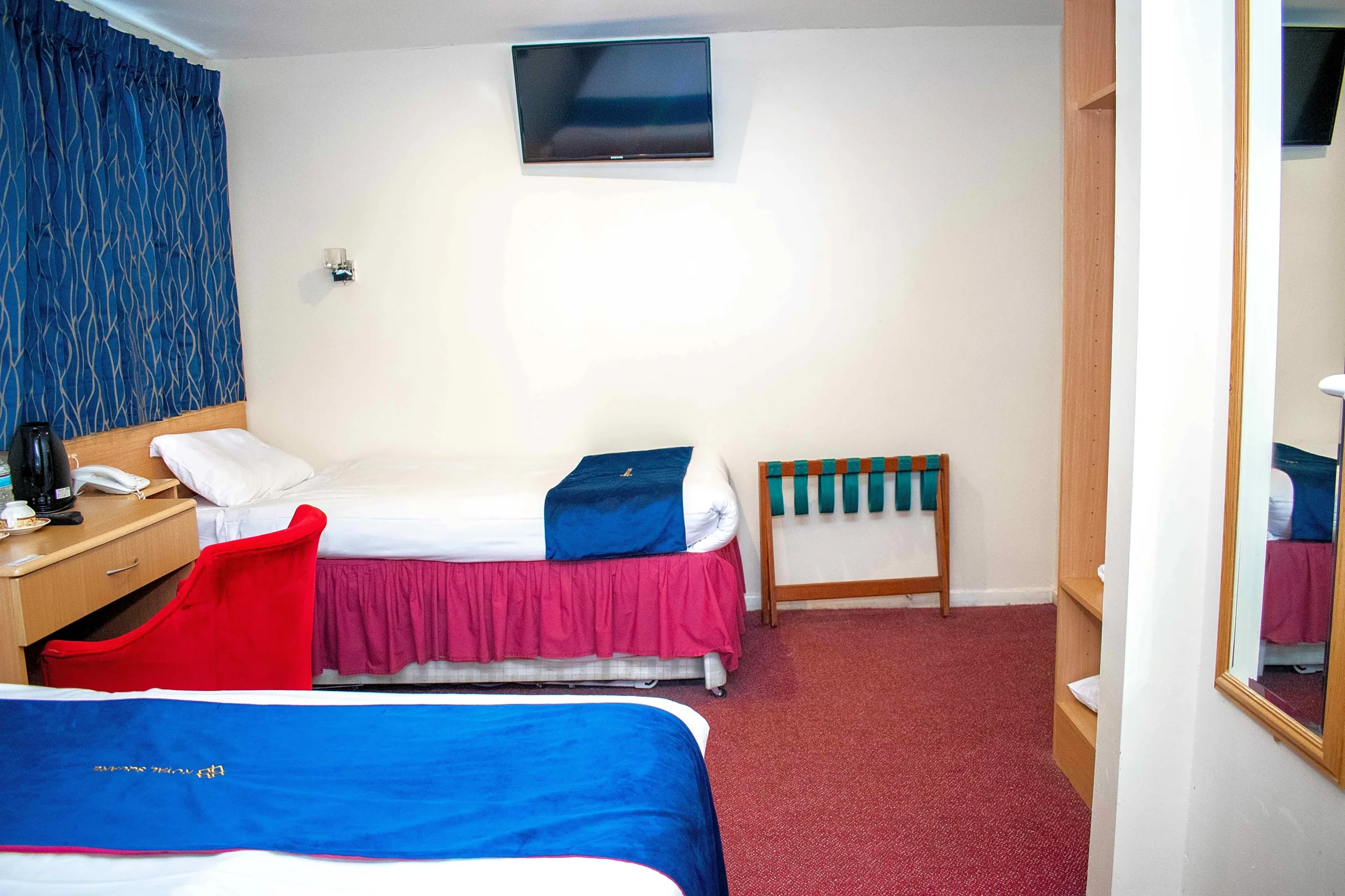 Family Room with several beds, a desk and a wall-mounted TV